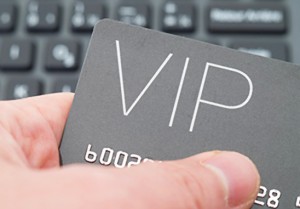 Hand holding VIP card against keyboard background